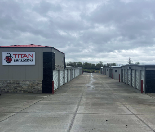 Titan Self Storage facility with rows of storage units along a concrete driveway under cloudy skies