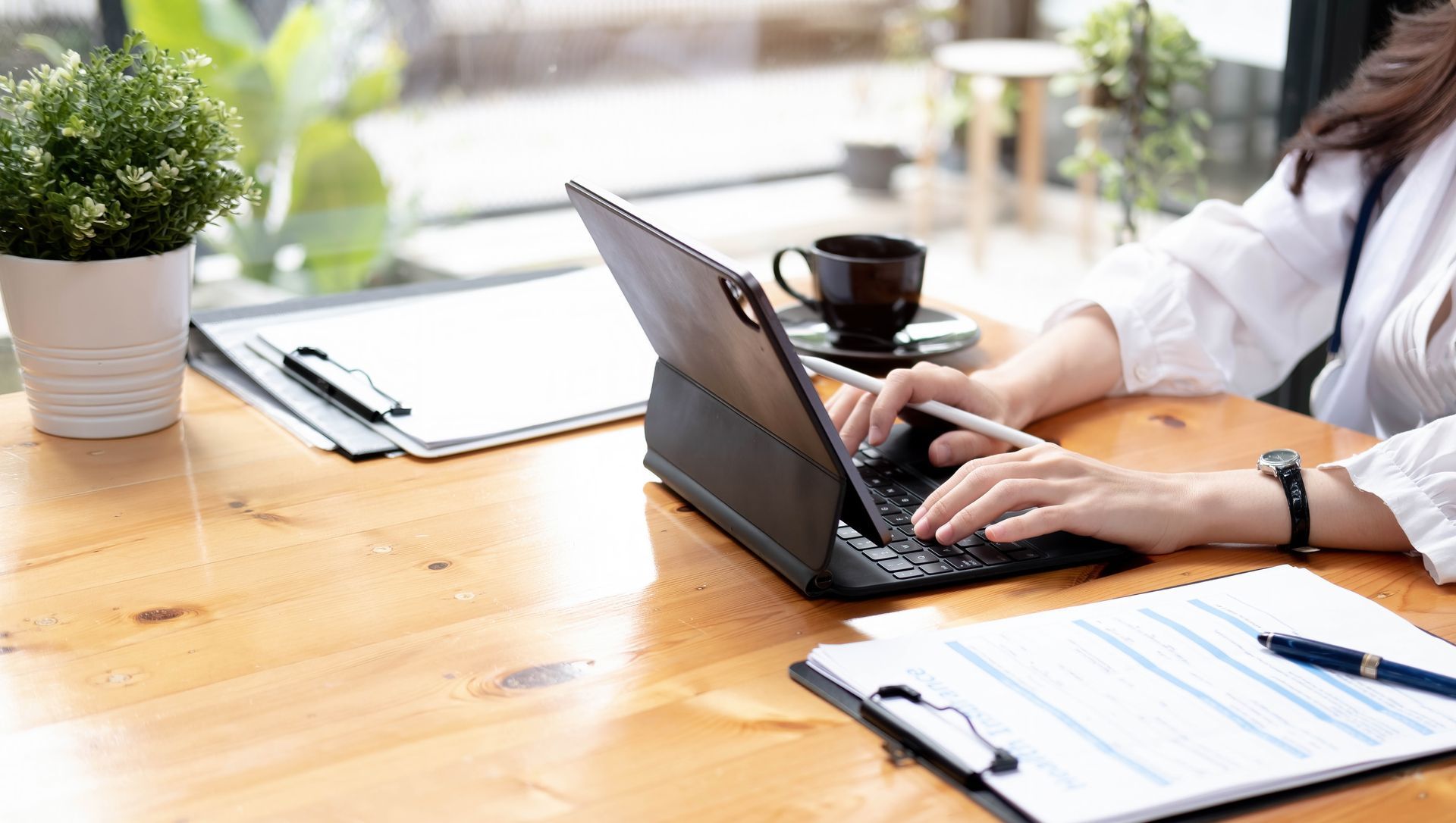 A man in a suit and tie is sitting at a desk using a laptop computer.