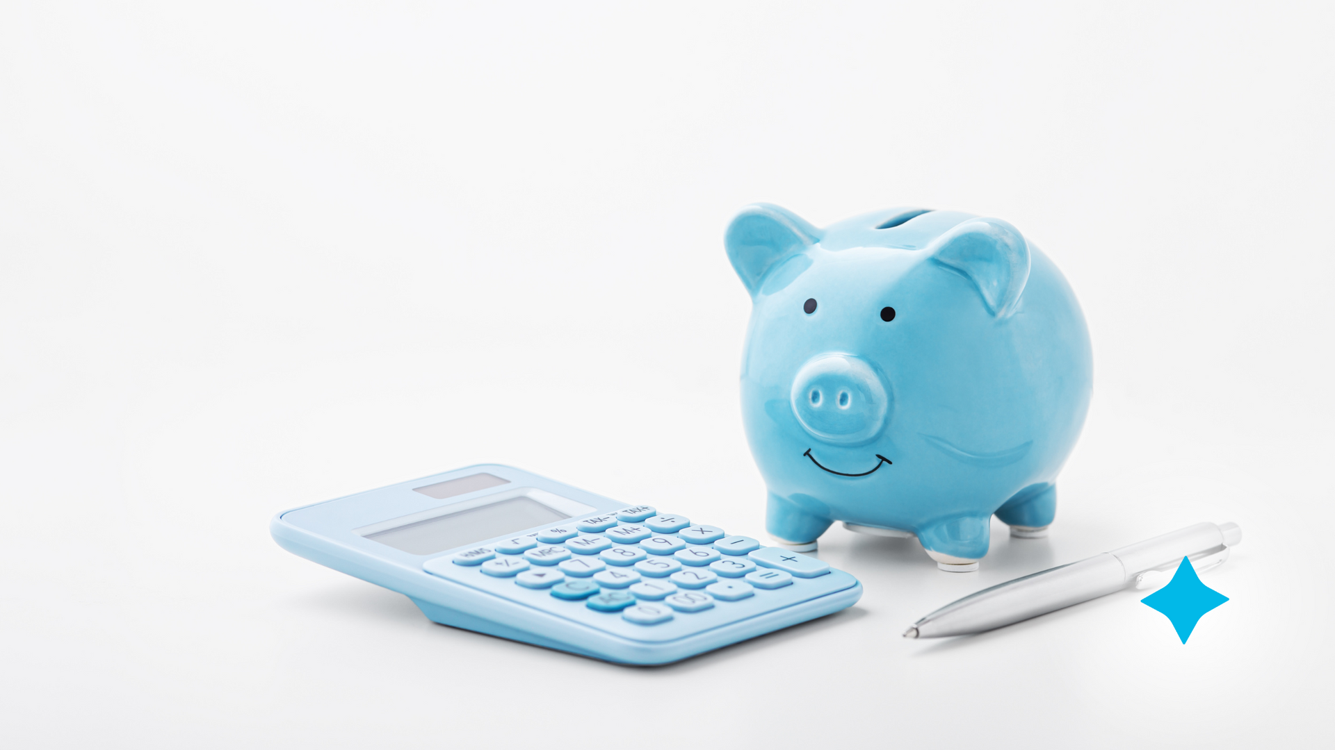A blue piggy bank is sitting next to a calculator and a pen.