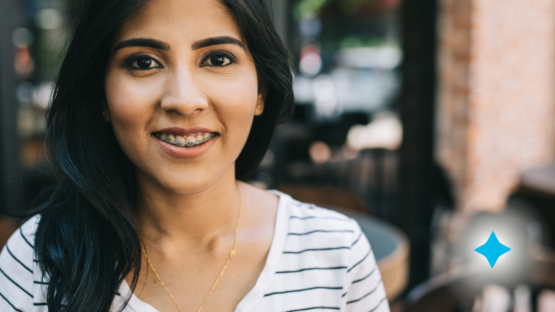 A woman with braces on her teeth is smiling for the camera.