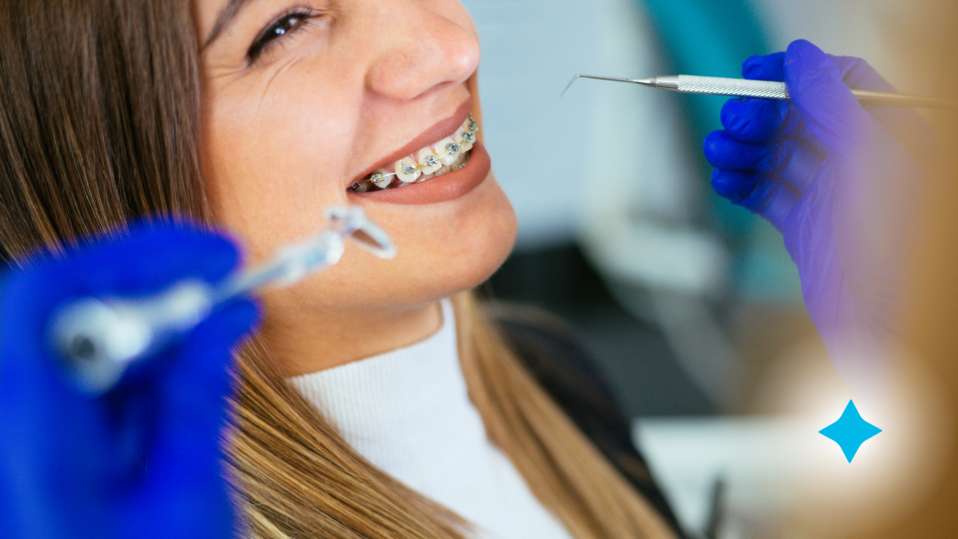 A woman with braces is getting her teeth examined by a dentist.
