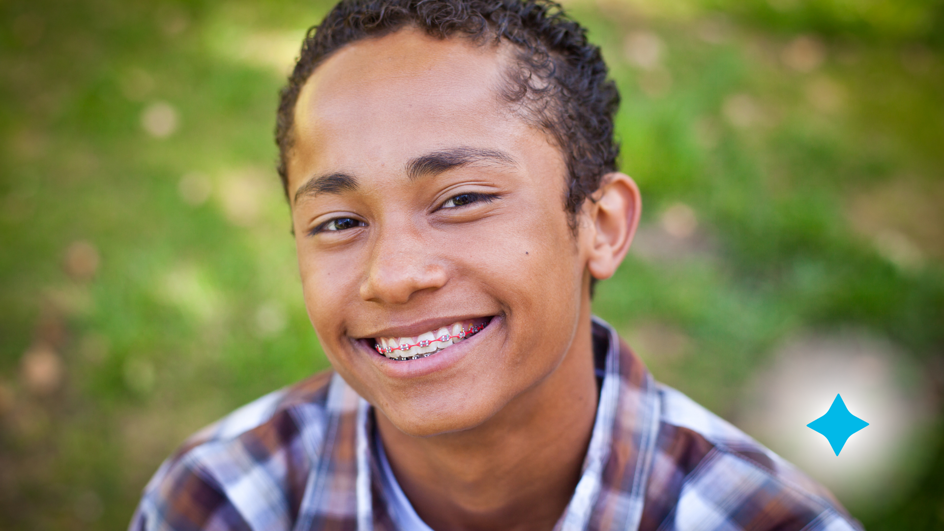 A young man with braces on his teeth is smiling for the camera.
