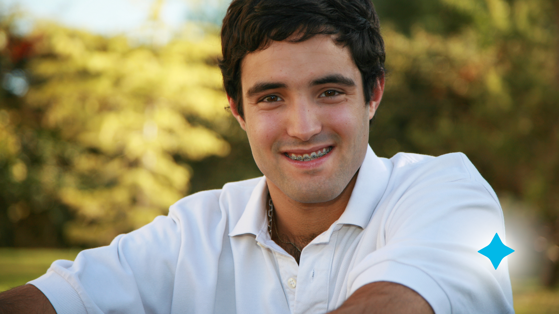 A man in a white shirt is smiling for the camera.