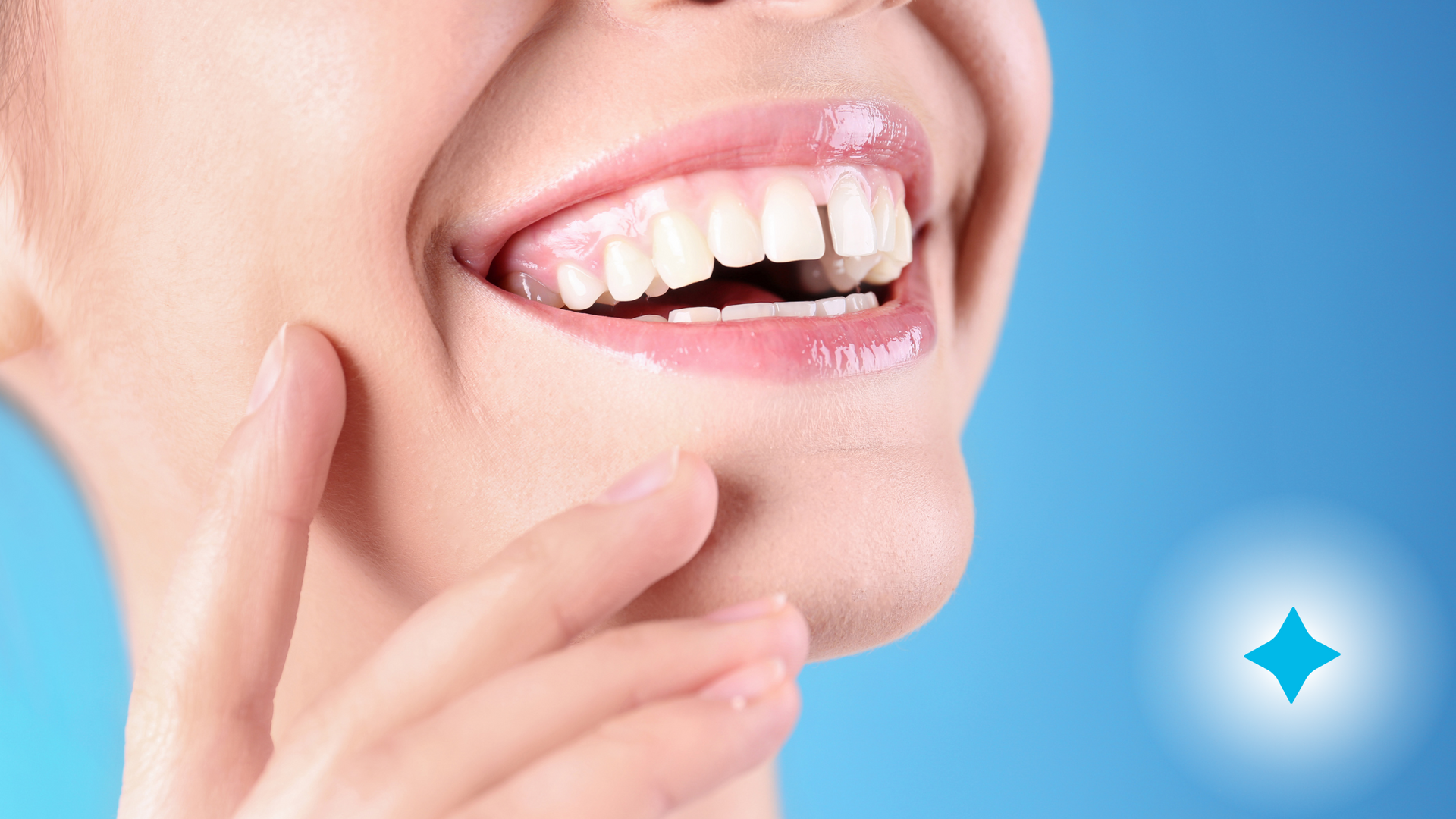 A close up of a woman 's smile with a blue background.