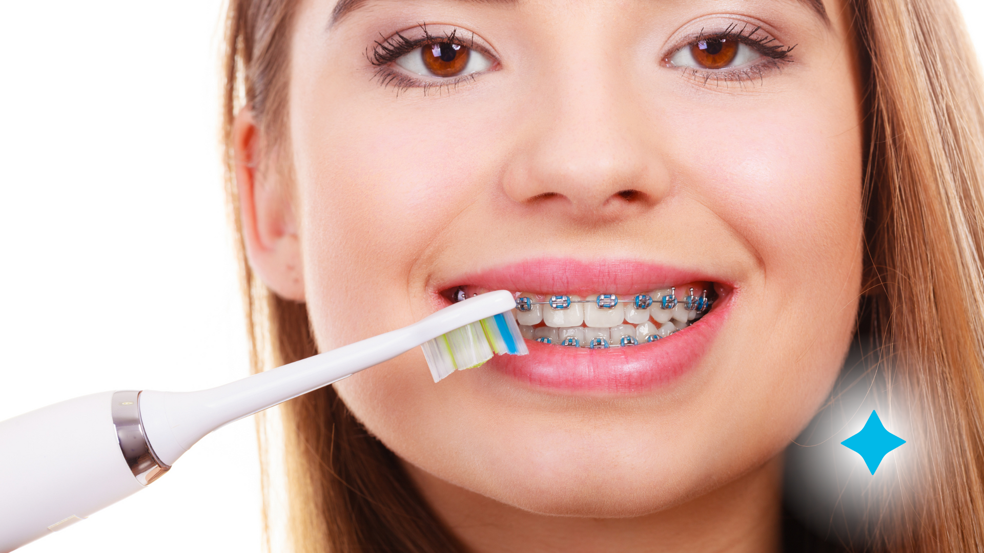 A woman with braces is brushing her teeth with an electric toothbrush.