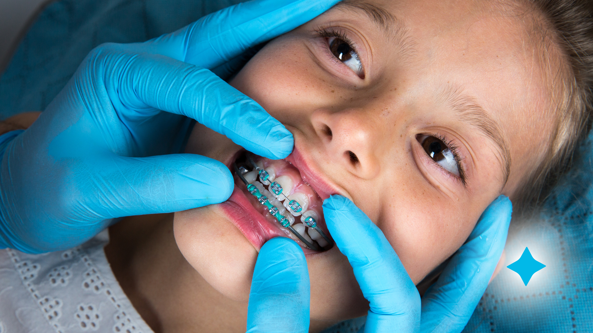 A young girl is getting her teeth examined by an orthodontist.
