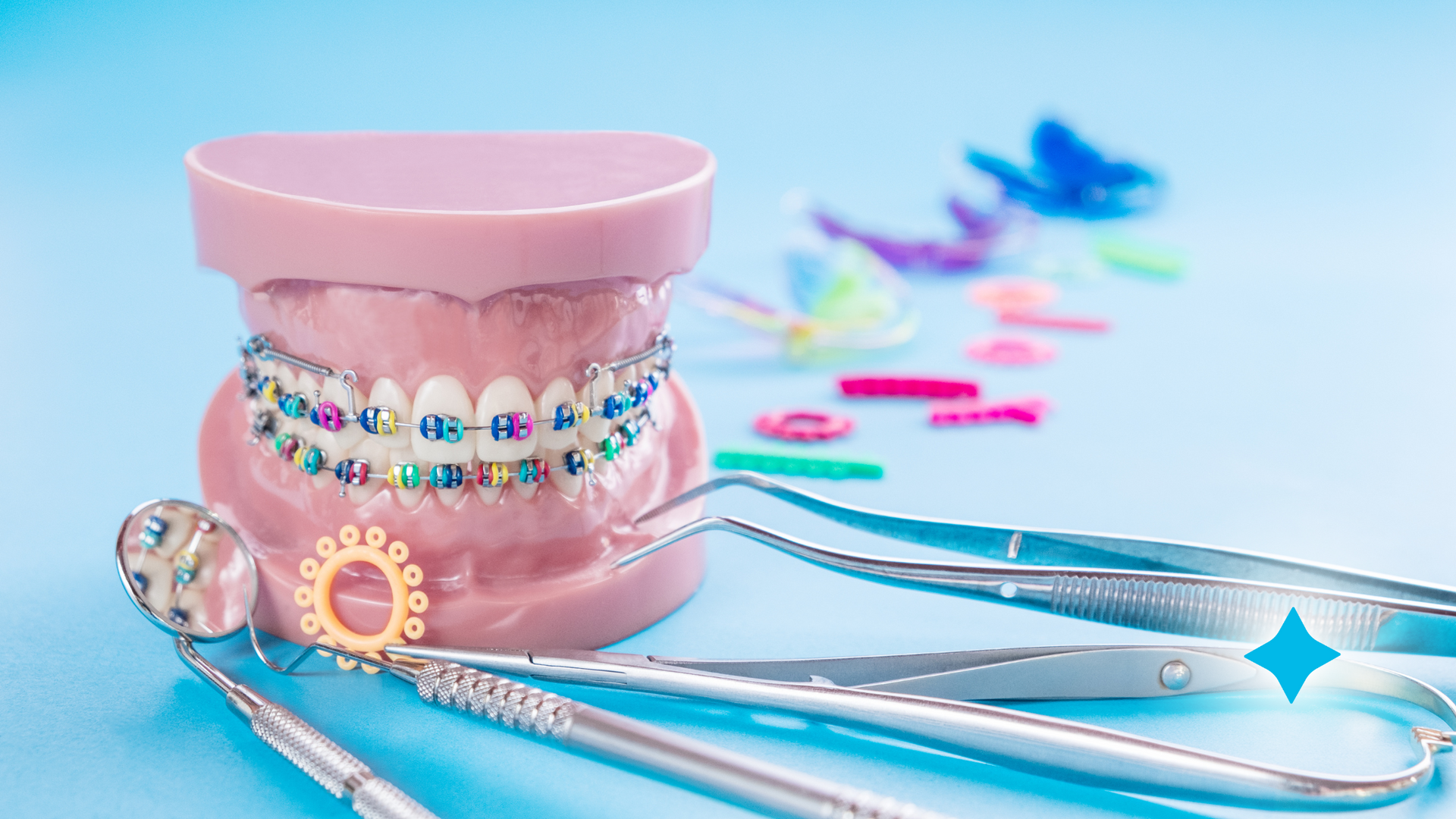 A model of teeth with braces and orthodontic instruments on a blue background.