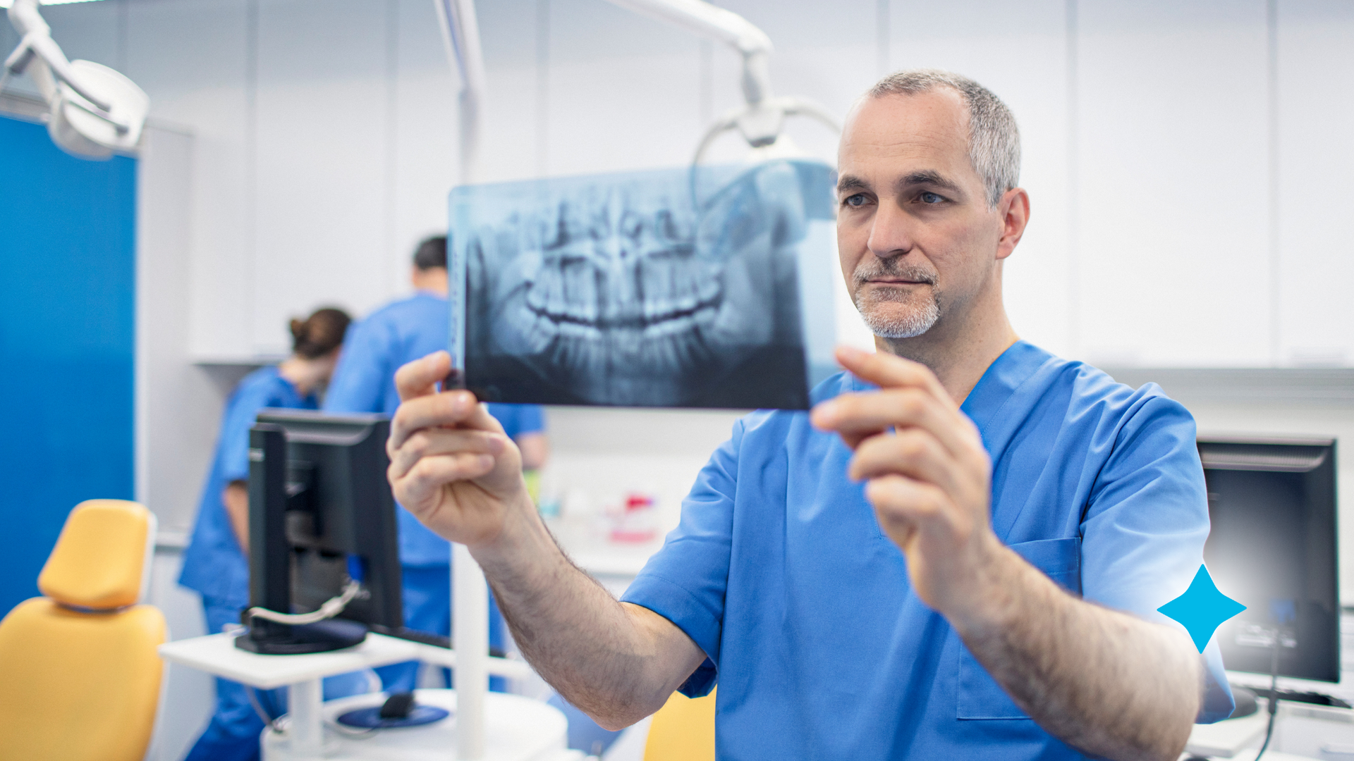 An orthodontist is holding an x-ray of a patient 's teeth in a dental office.
