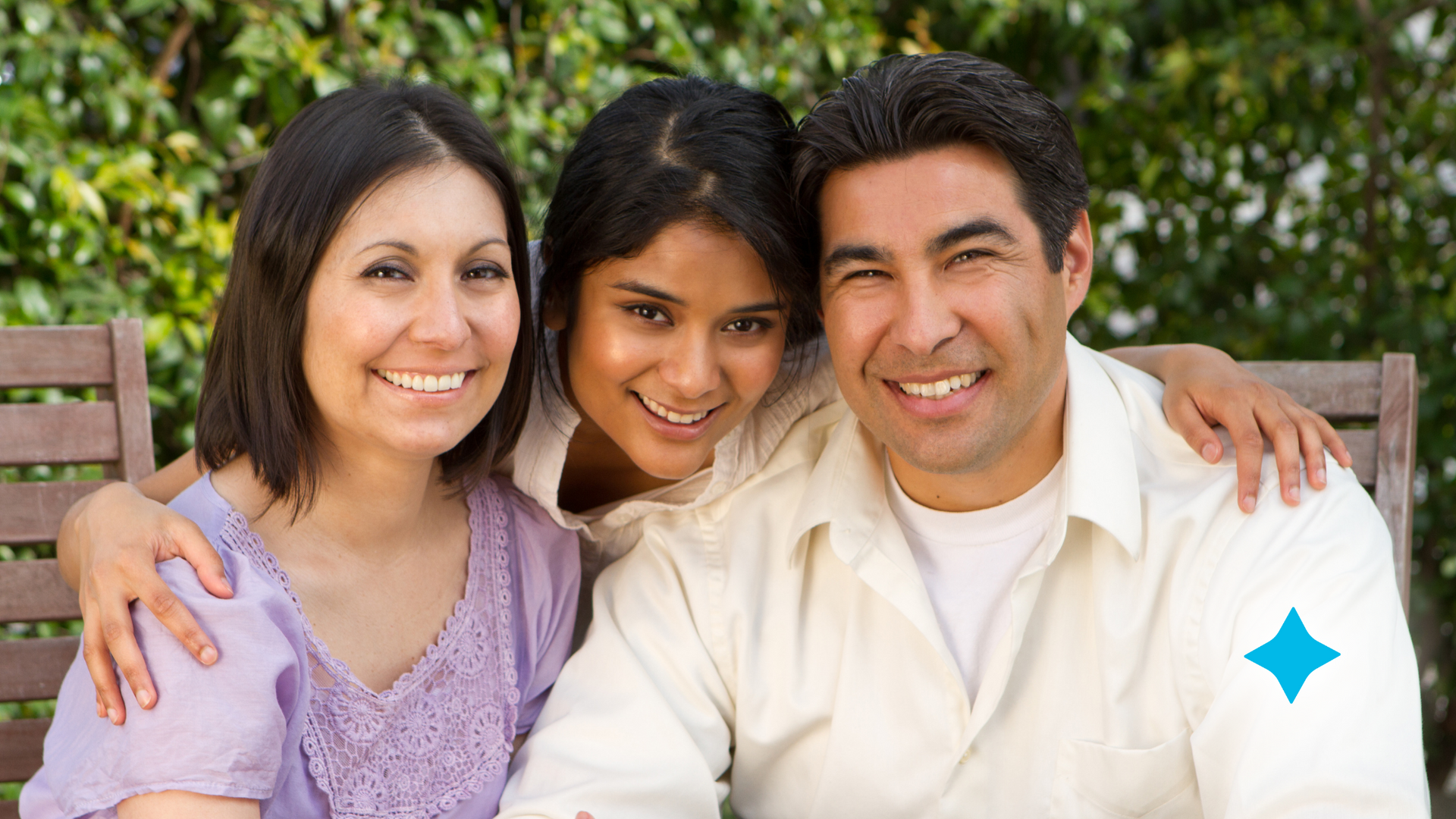 A man and two women are posing for a picture while sitting on a bench.