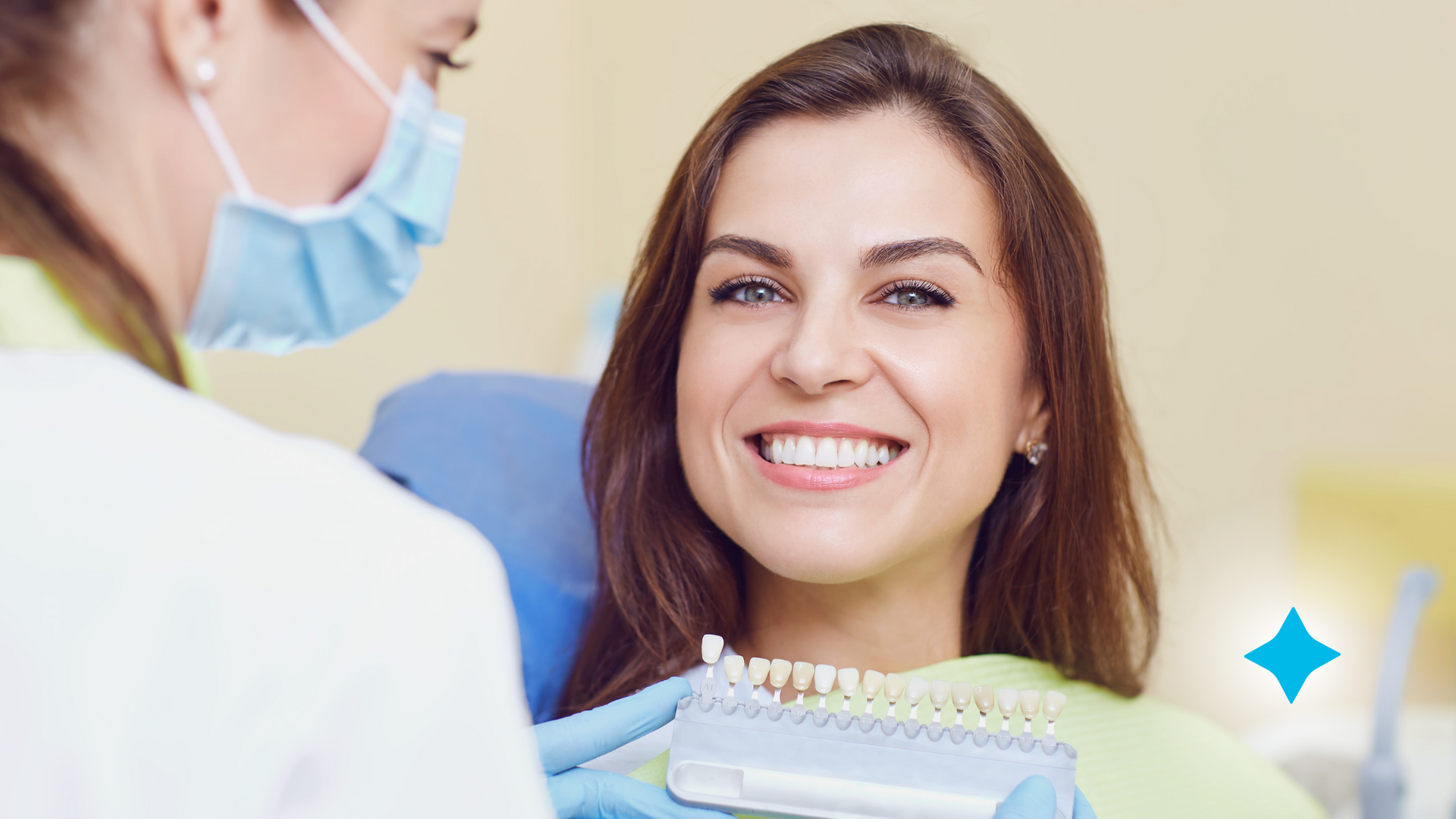A woman is smiling while sitting in a dental chair while an orthodontist examines her teeth.