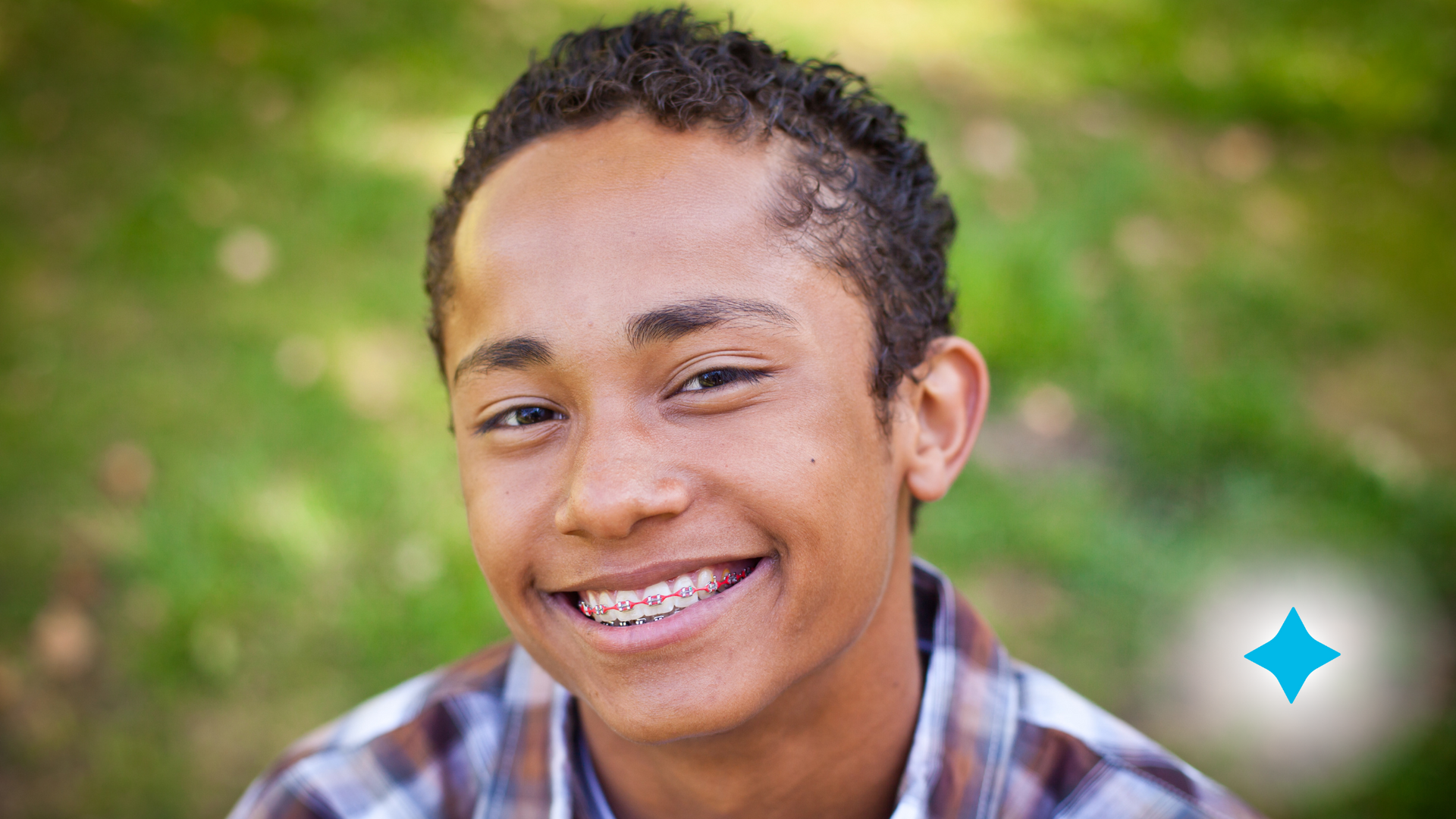 A young man with braces is smiling for the camera.
