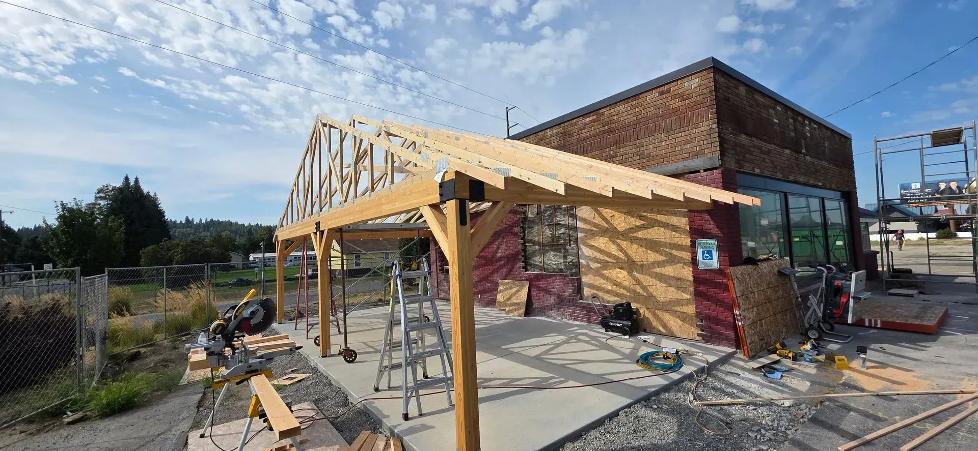 Partly built wooden frame beside a brick building at a construction site