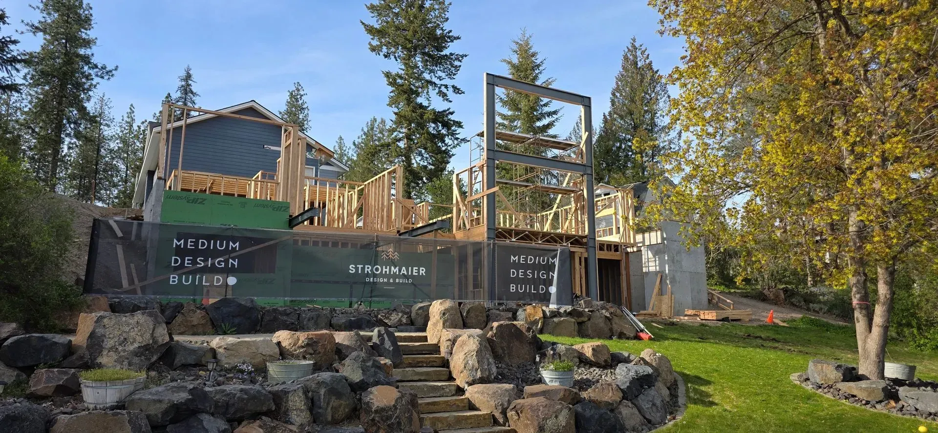 Wooden resort sign and deck among trees and rocks in a wooded landscape