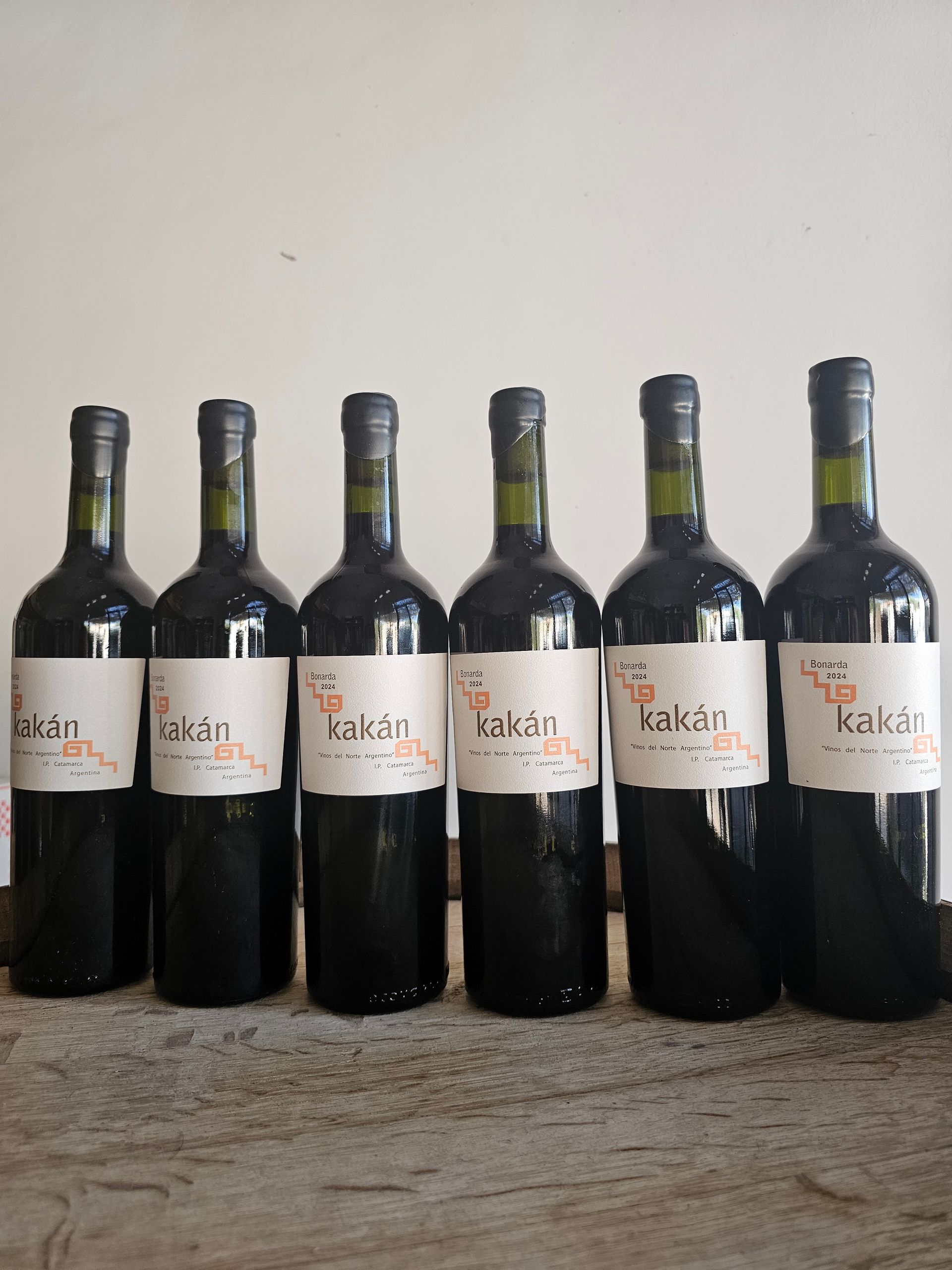 Seis botellas de vino tinto etiquetadas 
