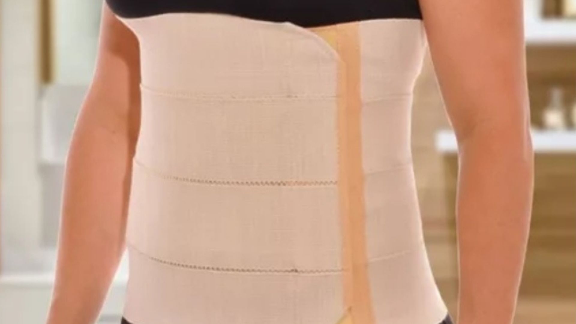 Mujer vistiendo una faja de soporte abdominal de color beige, diseñada para uso posparto o posquirúrgico.