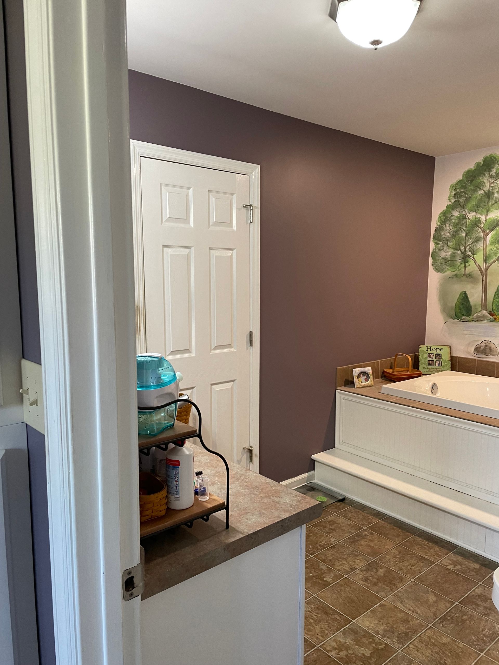 Small laundry room with a washer and dryer, towels draped over them, and an open closet doorway.