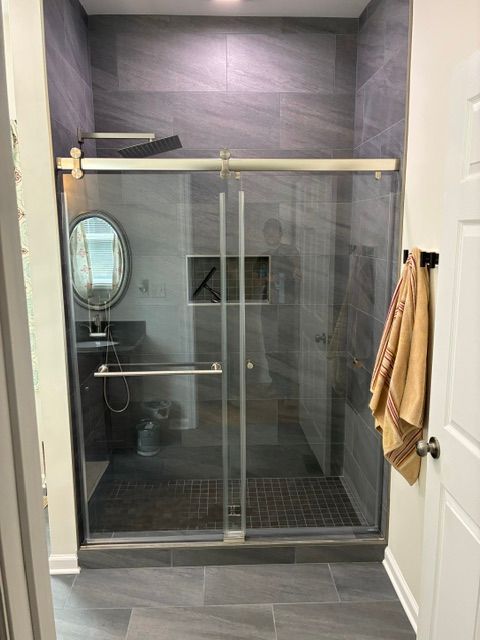 Double vanity bathroom with white cabinets, large mirrors, and gray walls in a bright, modern interior