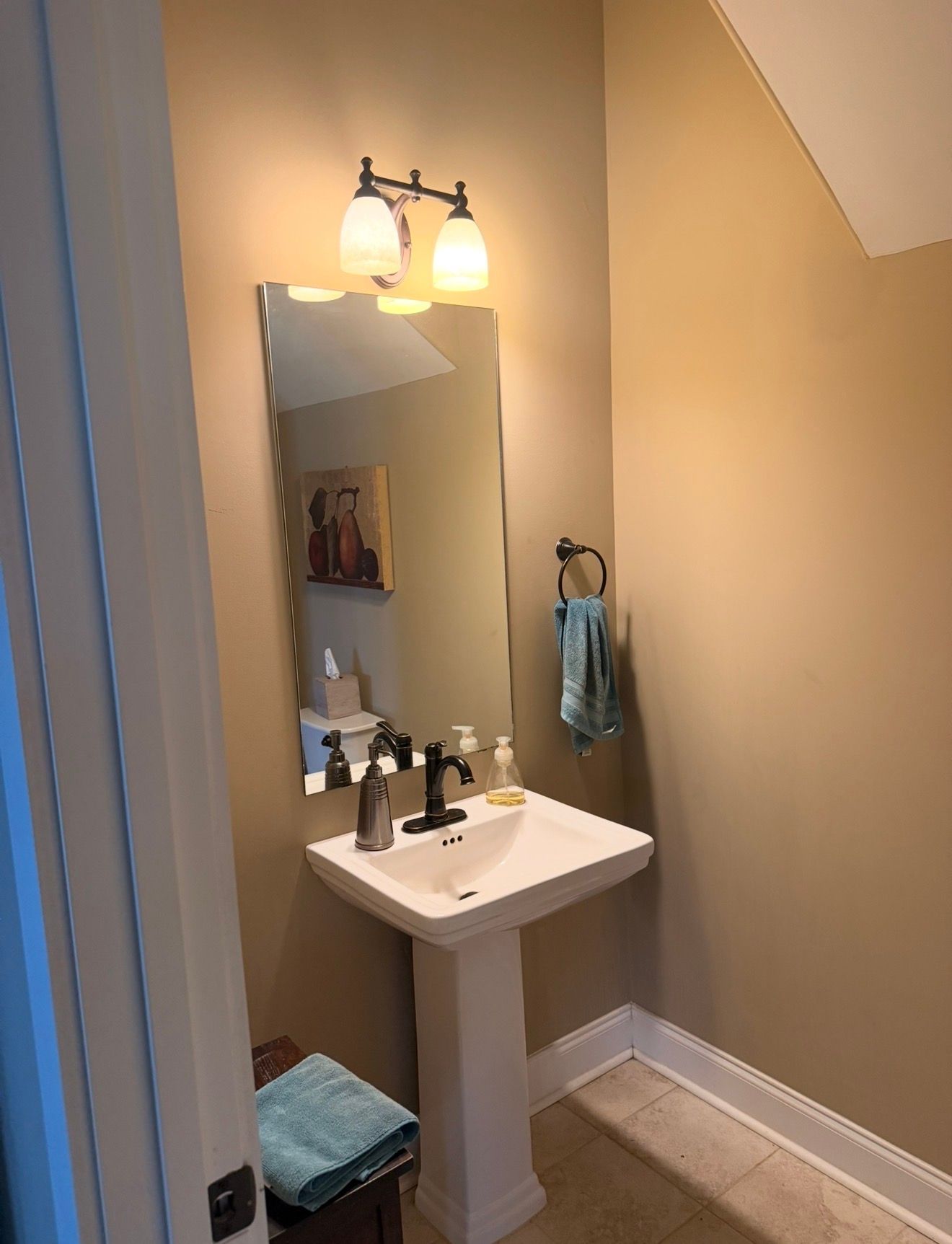 Blue floral bathroom with a corner tub, red flowers, and a vanity with mirror in an adjoining room