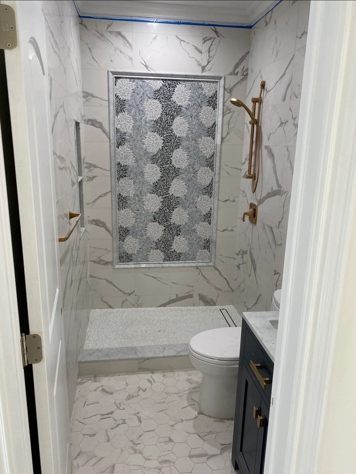 A bathroom with a toilet , sink and shower.