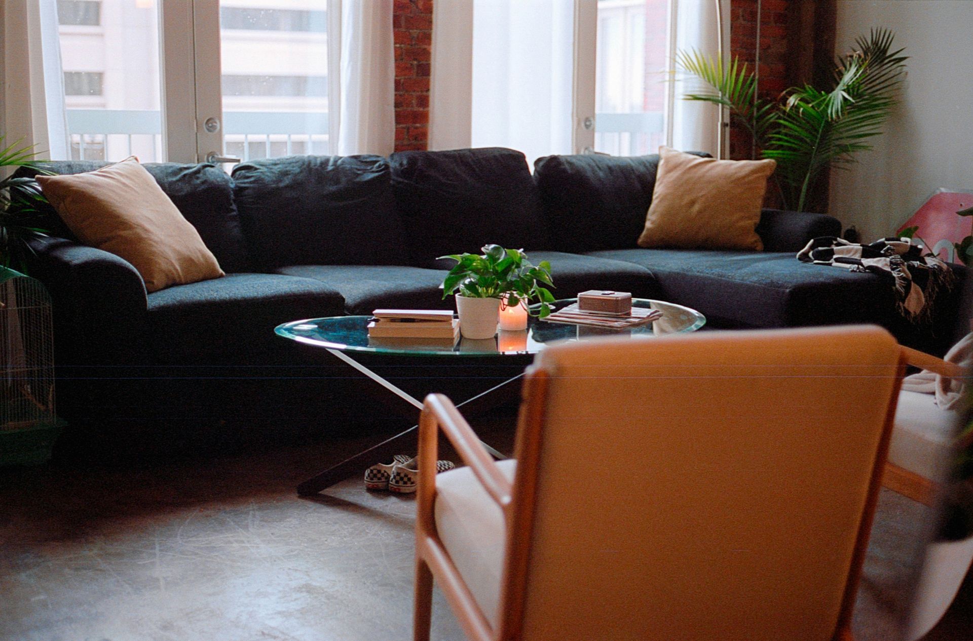 Living room with blue sectional sofa, coffee table, and tan chair.