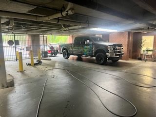 Truck parked in a dim garage with cables on the floor and daylight visible outside