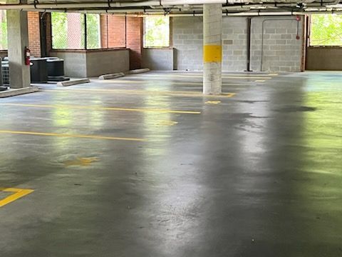Empty indoor parking garage with wet concrete floor and yellow lane markings