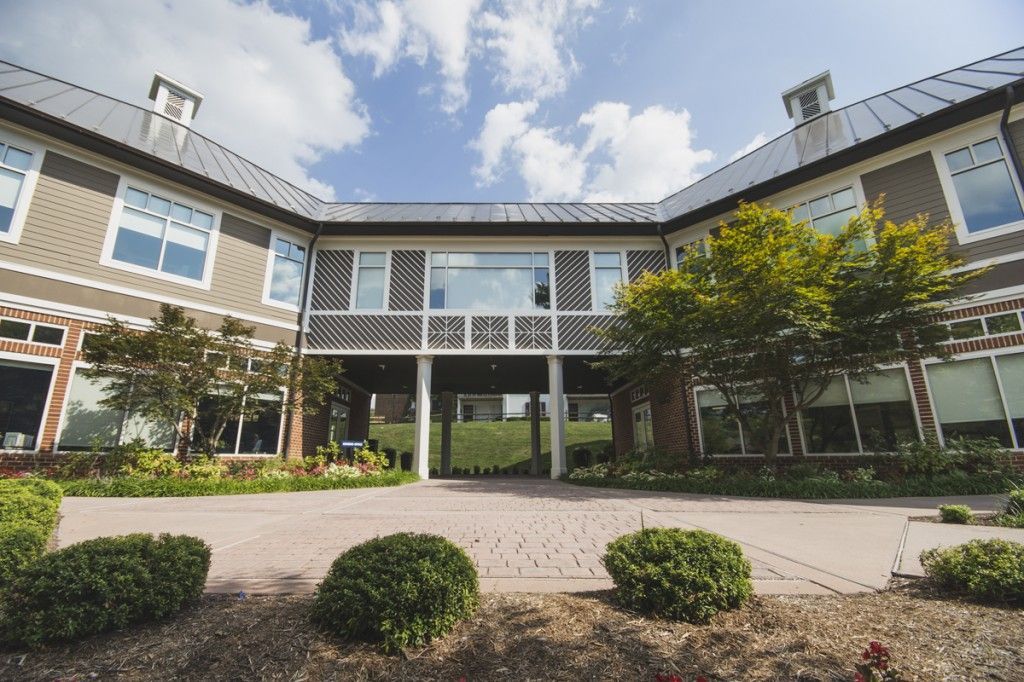 A large building with a lot of windows and trees in front of it.
