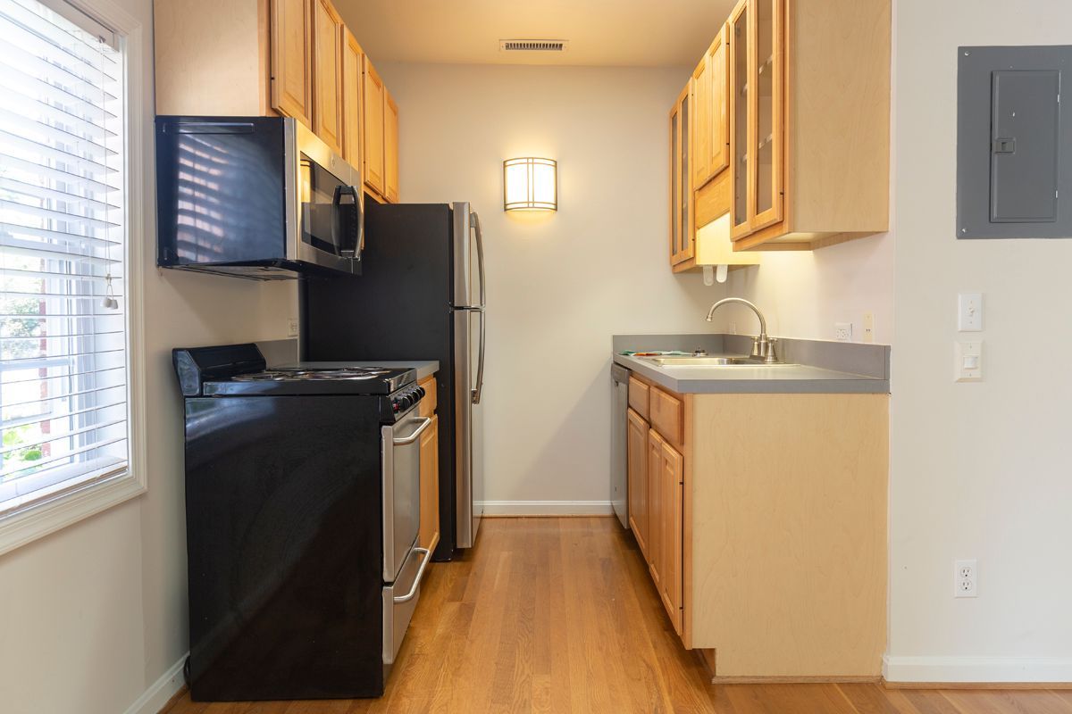 Small kitchen with light wood cabinets, stainless steel appliances, and a window.