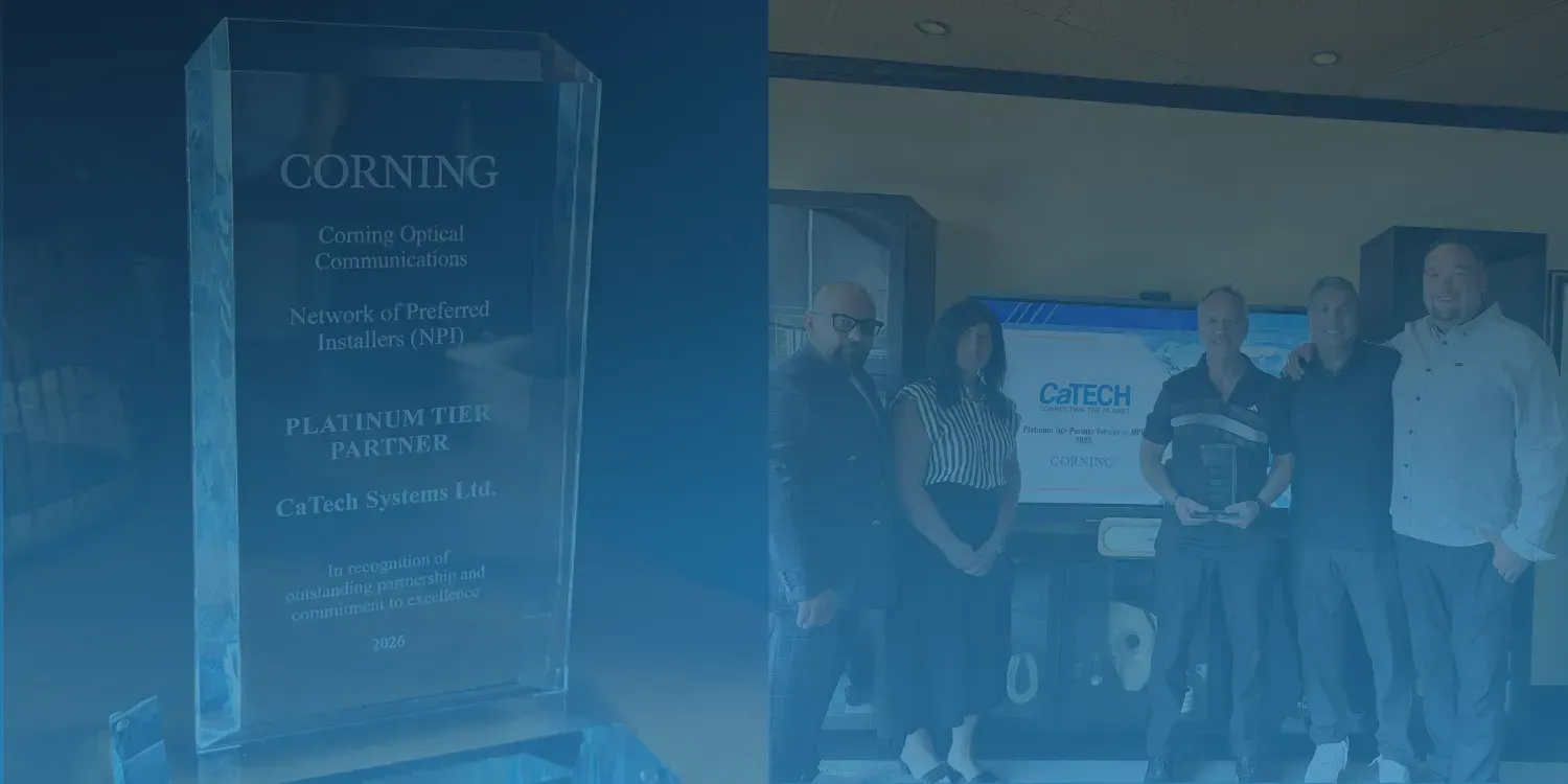 Blue-tinted photo of a group standing beside a glowing display plaque indoors.