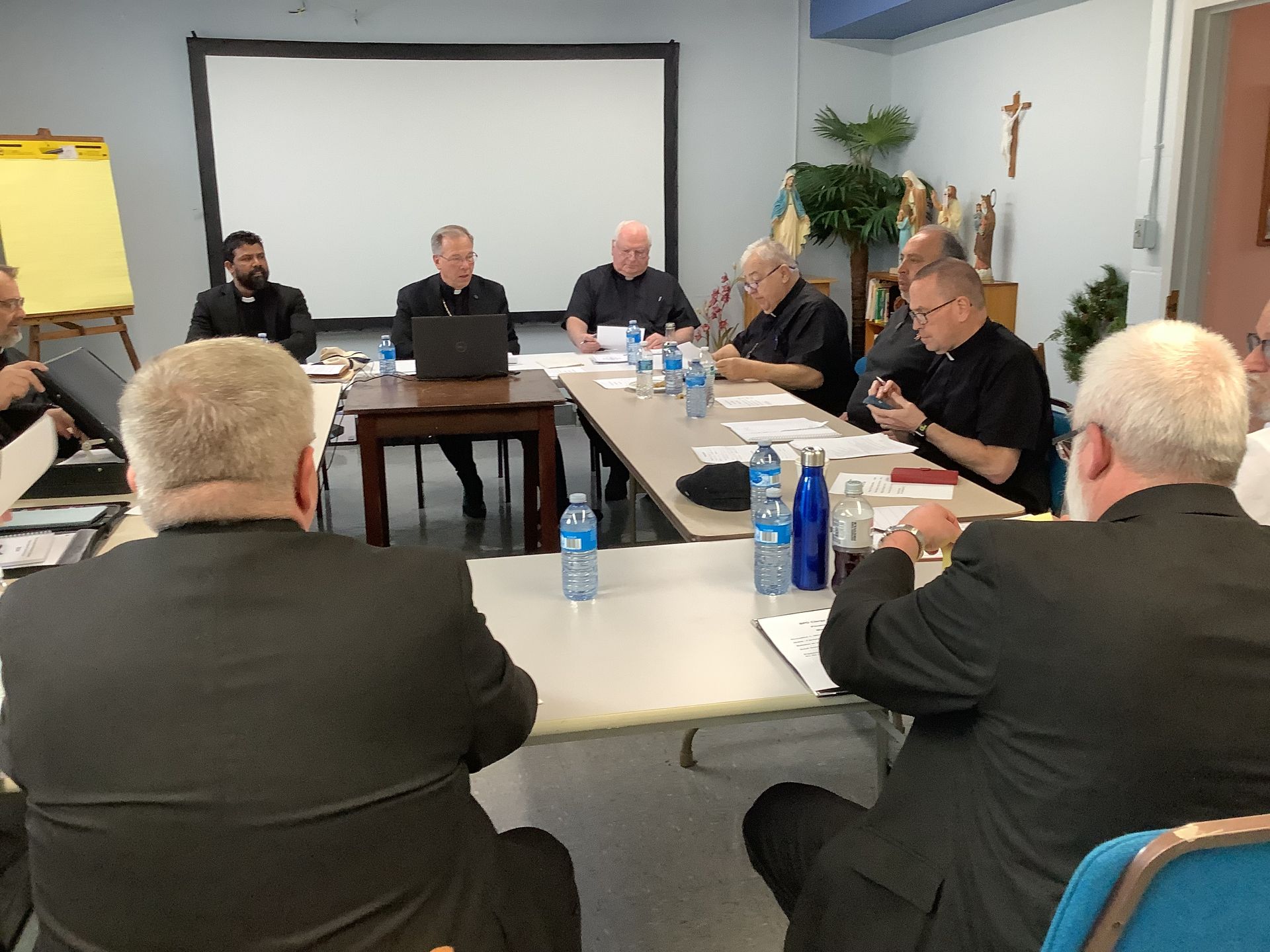 A group of men are sitting around a table having a meeting