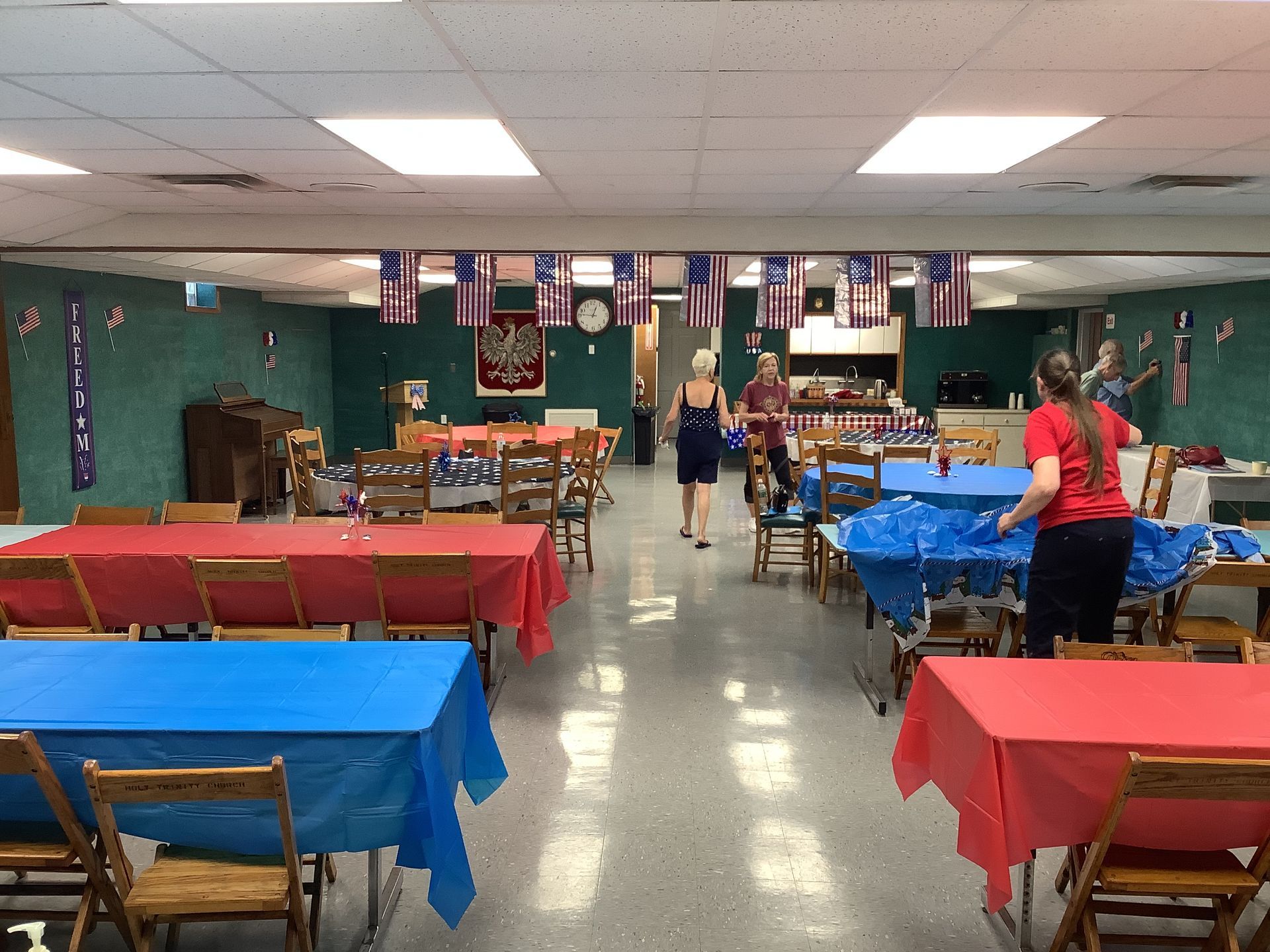 A large room with tables and chairs and flags hanging from the ceiling