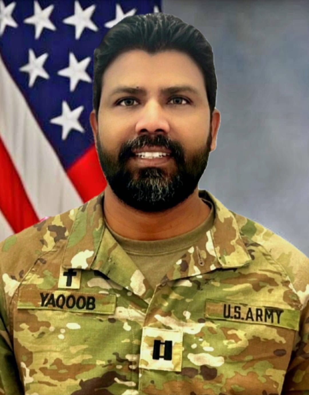 A man in a military uniform is standing in front of an american flag.