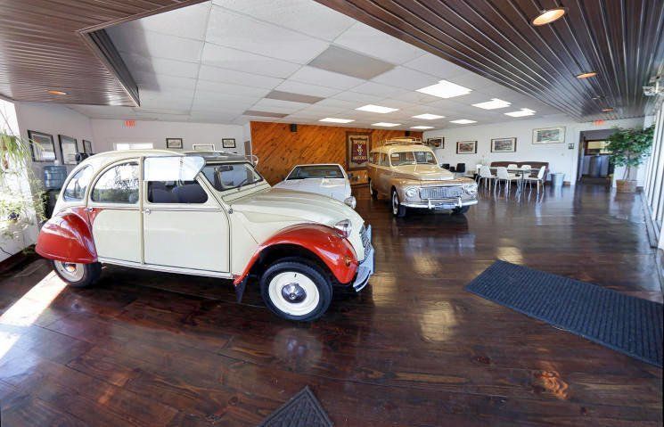 Classic red and white vintage car in a museum showroom with another car in the background