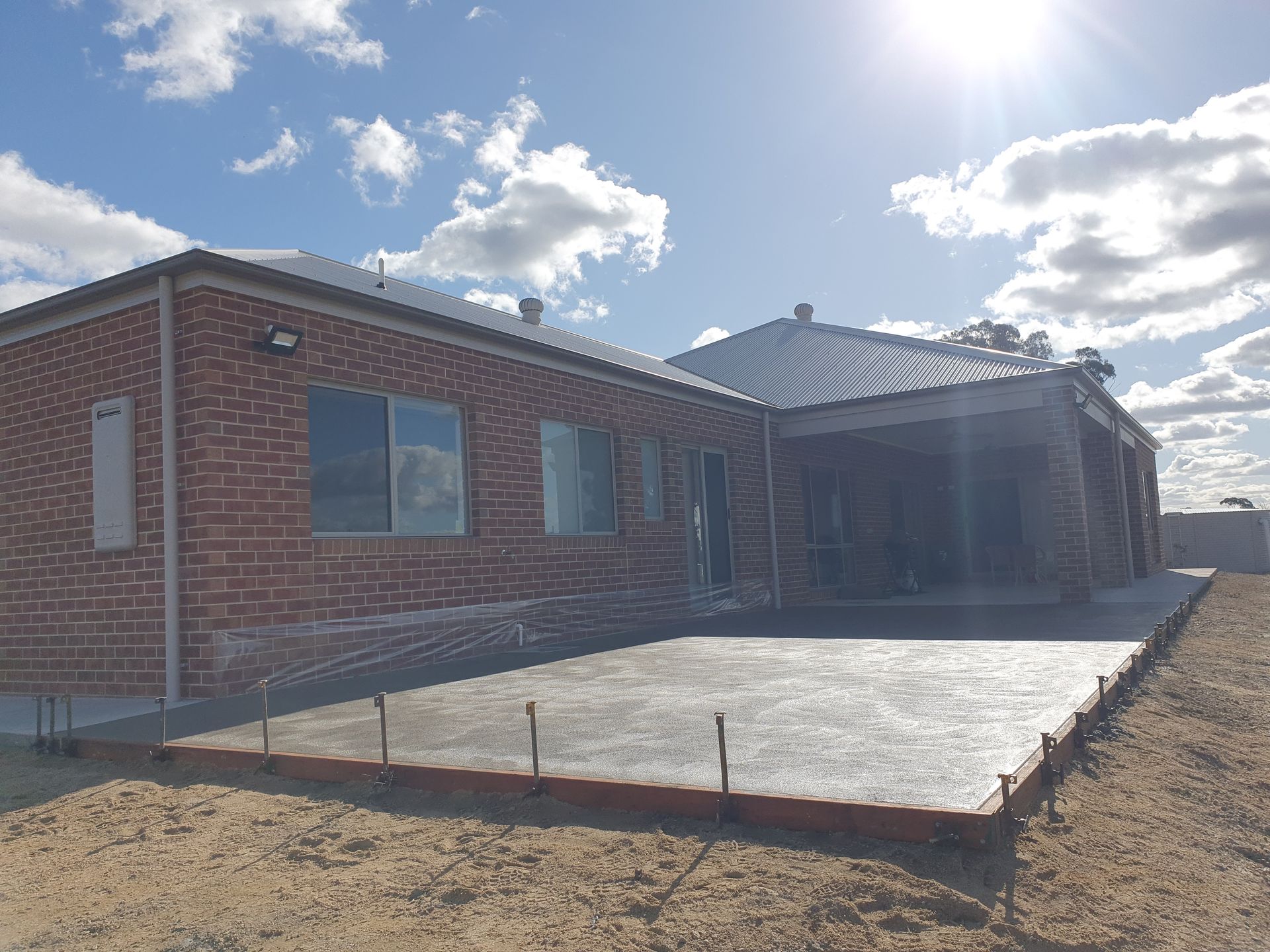 A brick house with a concrete slab in front of it.