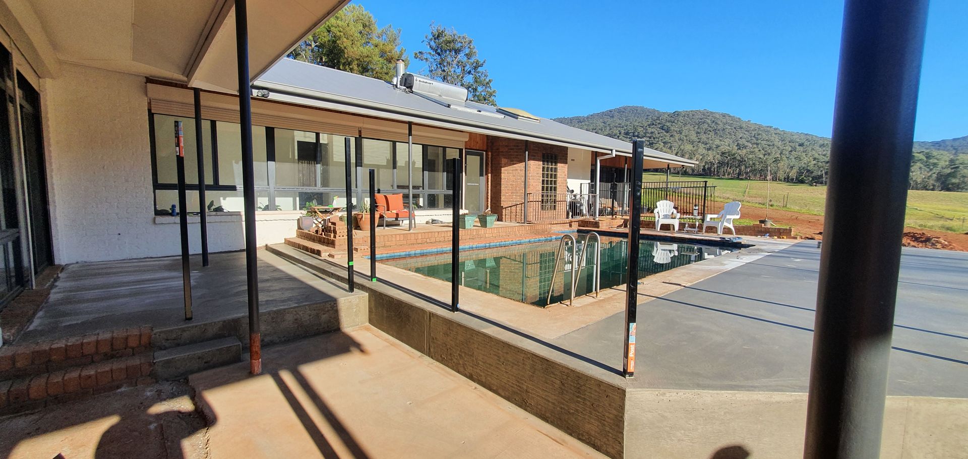 There is a swimming pool in the backyard of a house.