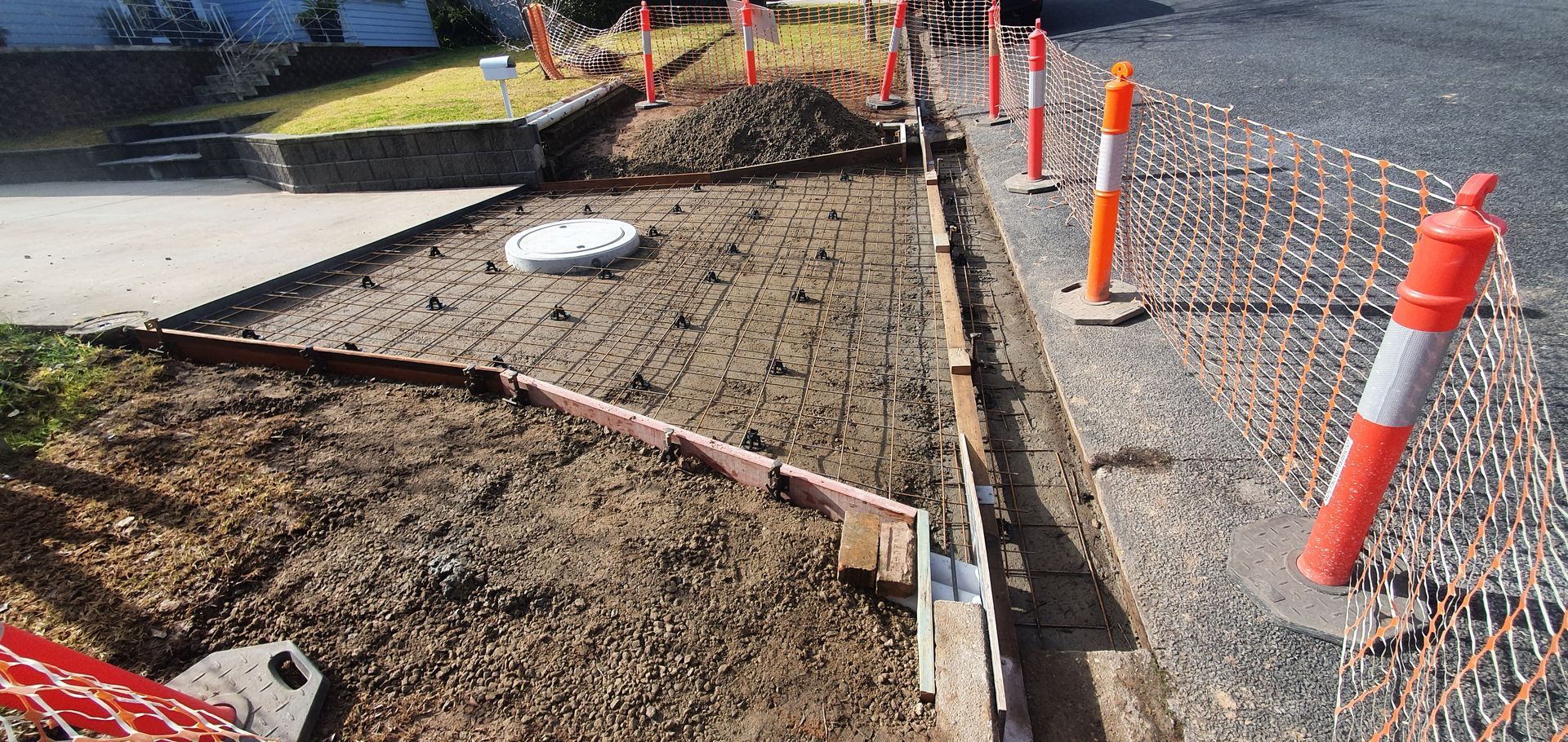 A concrete sidewalk is being built on the side of the road.