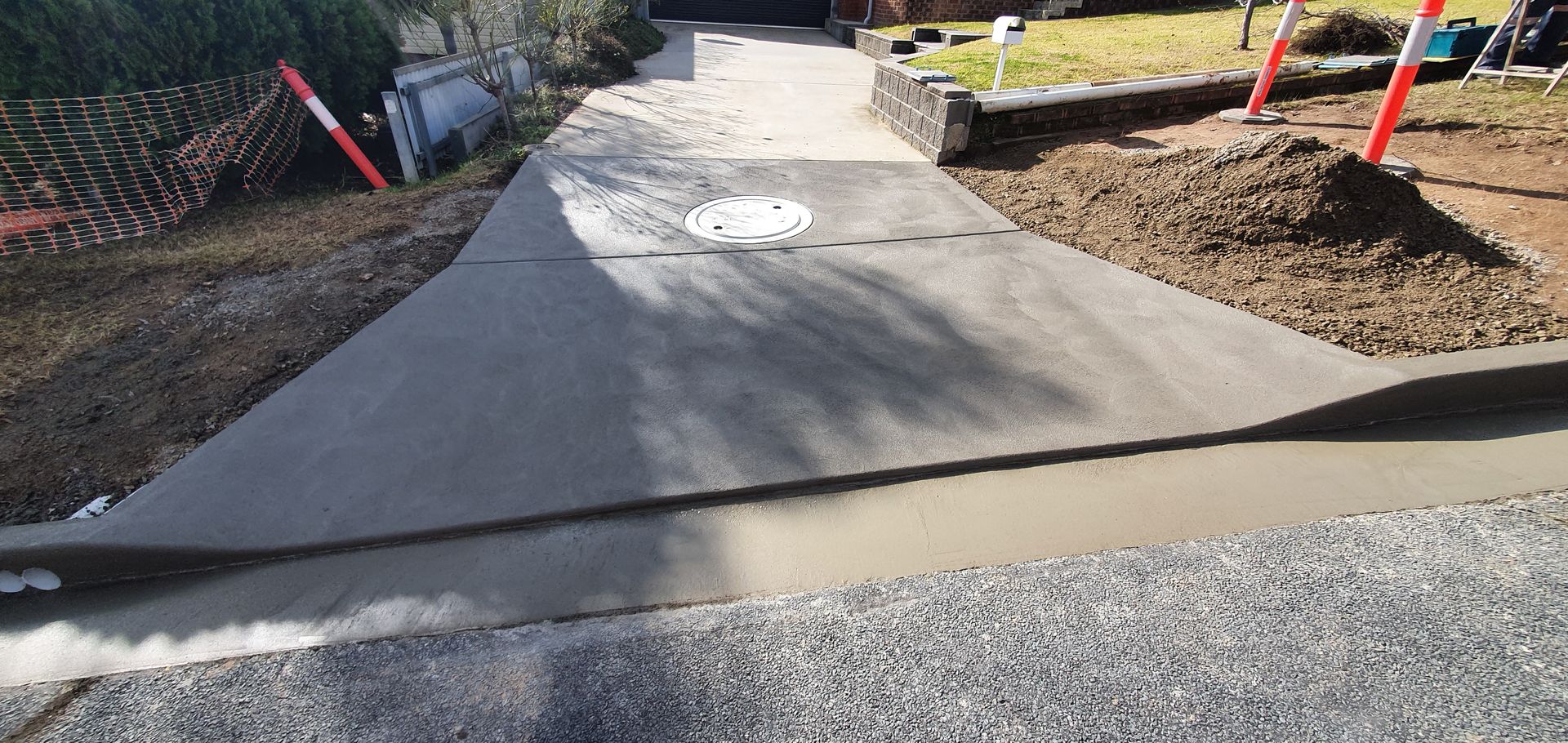 A concrete walkway is being built next to a gravel road.