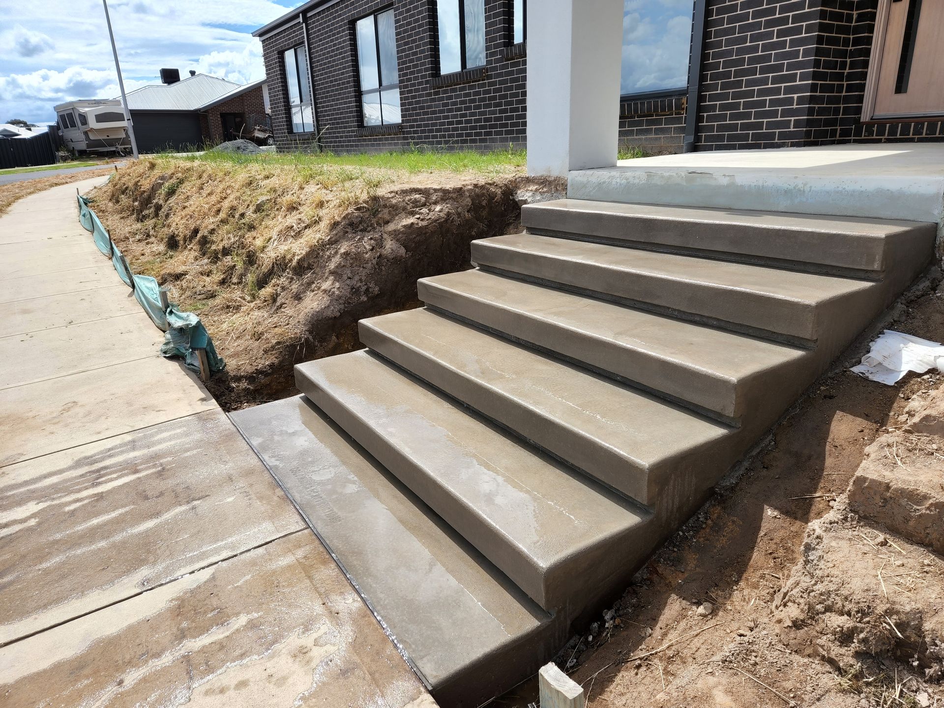 A set of concrete stairs leading up to a house under construction.