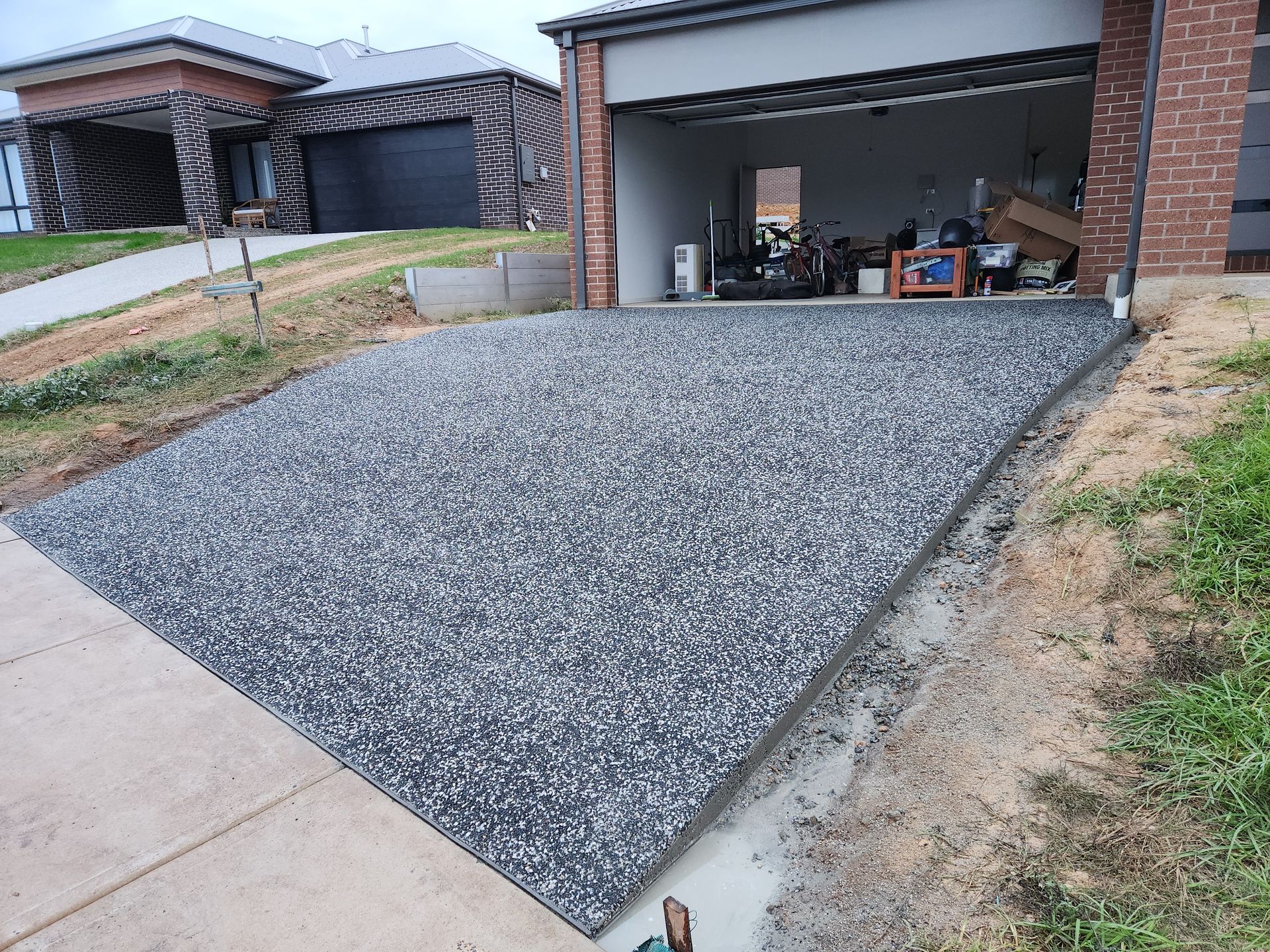 A concrete driveway is being built in front of a garage.