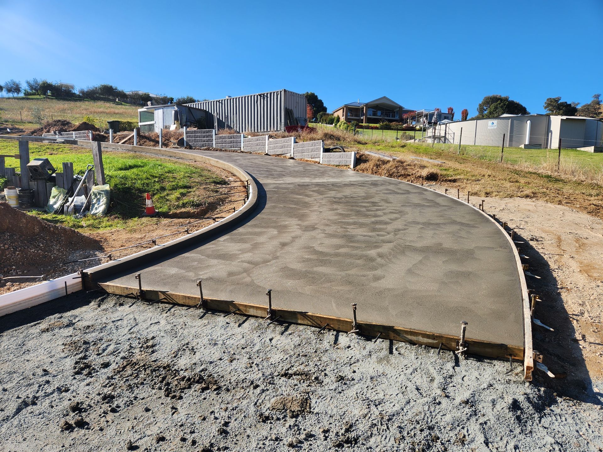 A concrete driveway is being built in a rural area