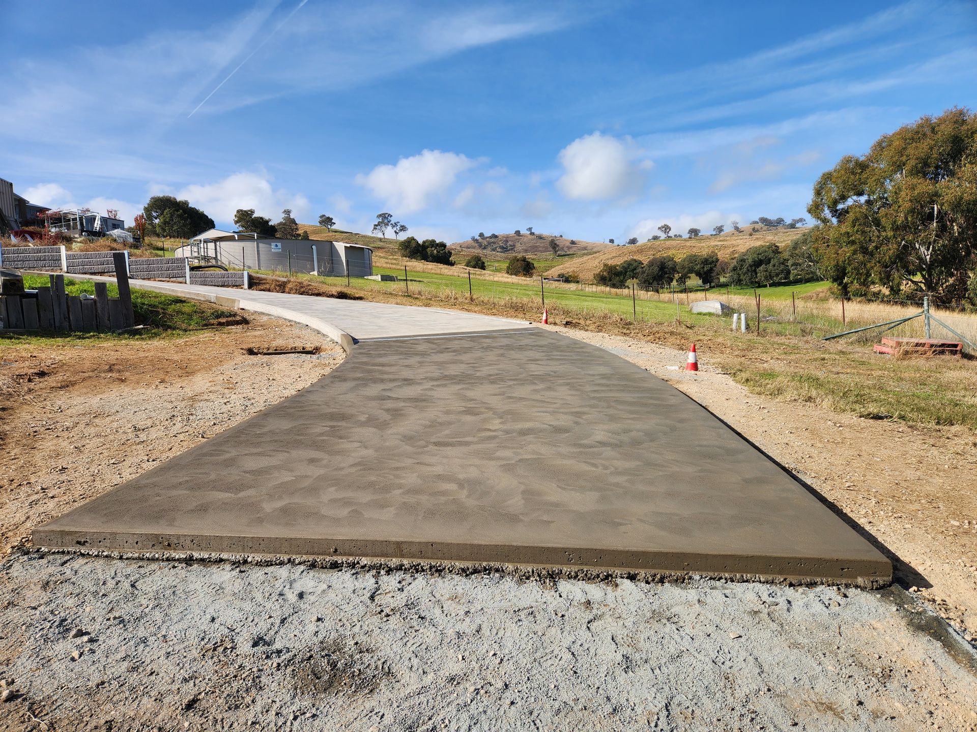 A concrete driveway is being built in the middle of a dirt field.