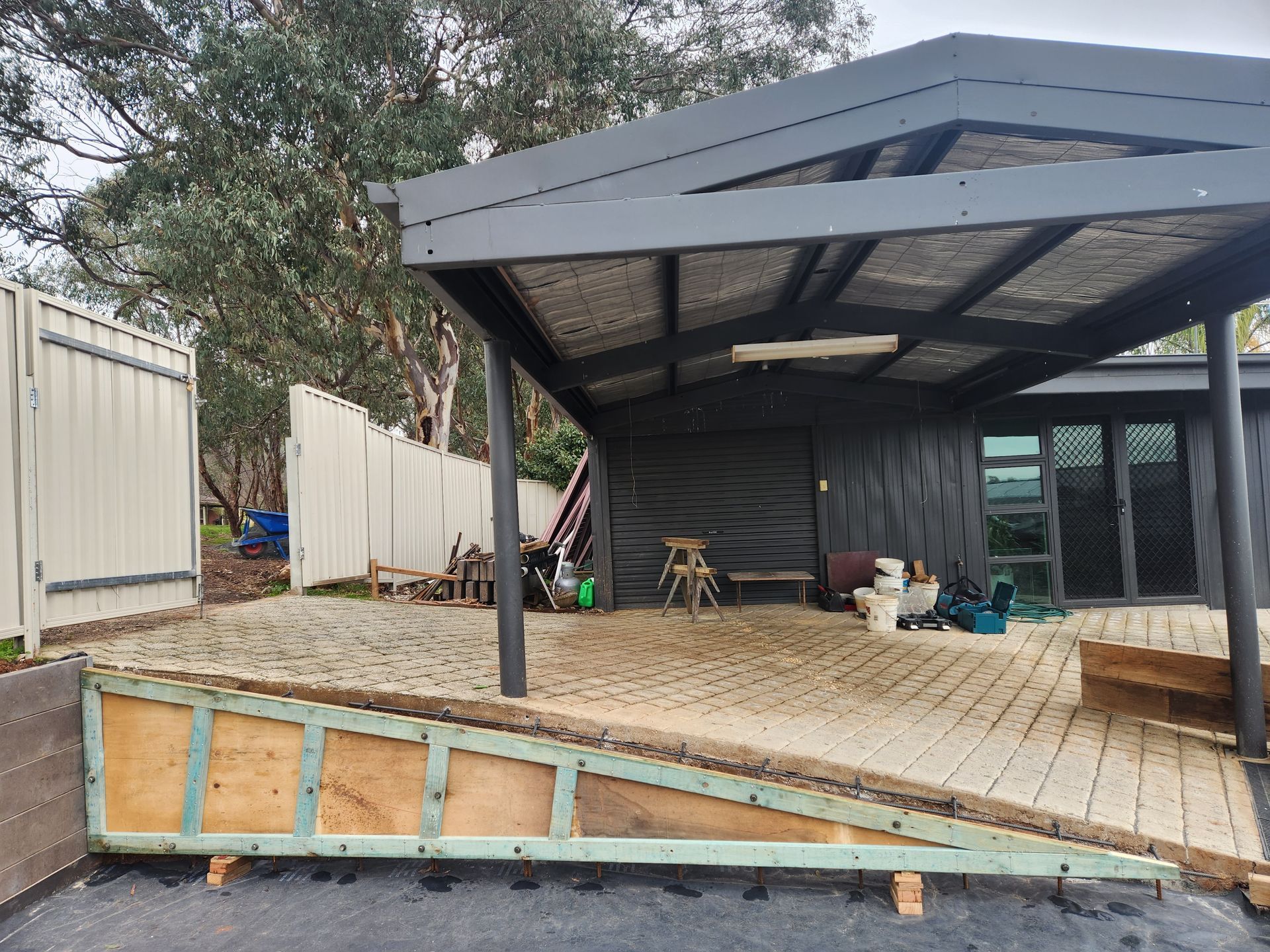 A house with a carport and a ramp in front of it.