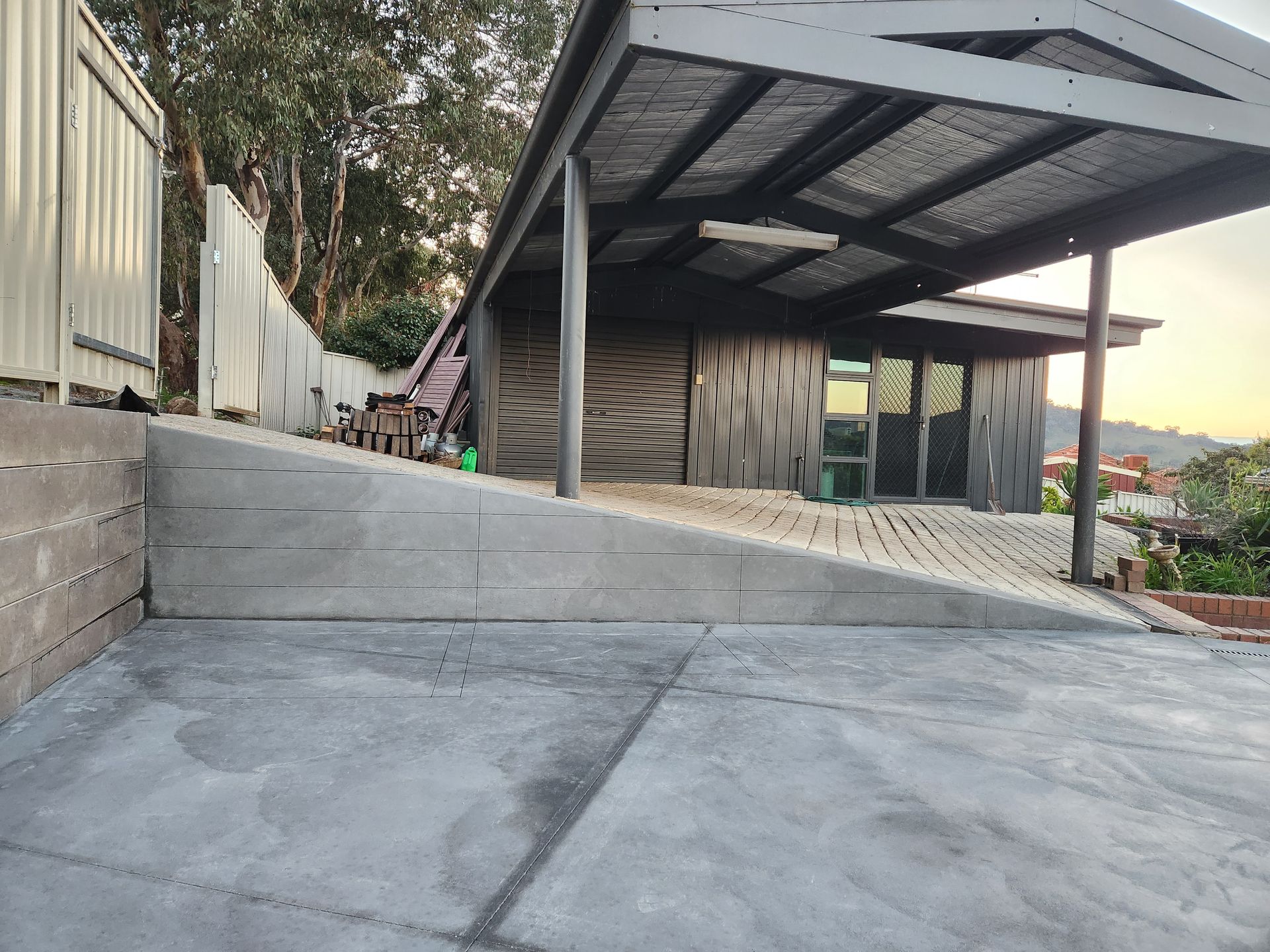 A concrete ramp leading to a house with a canopy over it