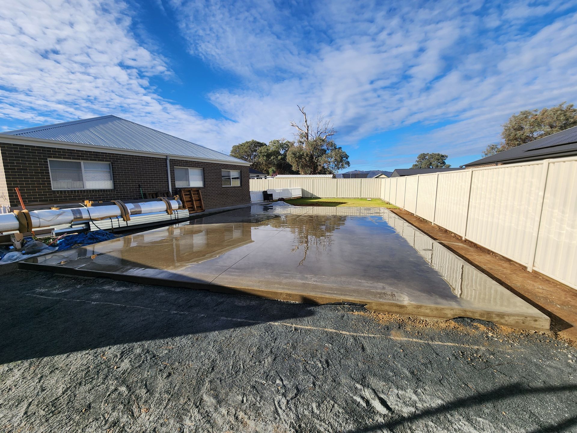 Newly poured cement slab next to a house — Colombera Constructions In Wodonga, VIC