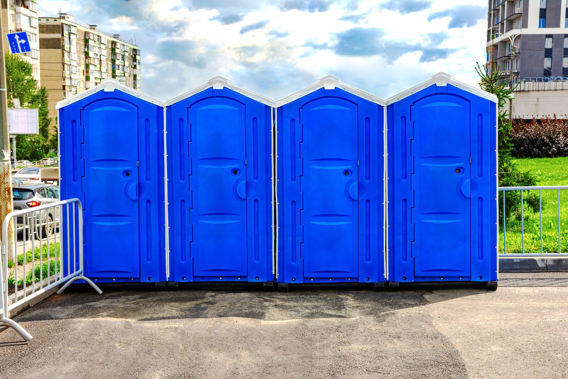 Portable restroom units lined up outdoors at a construction or event site