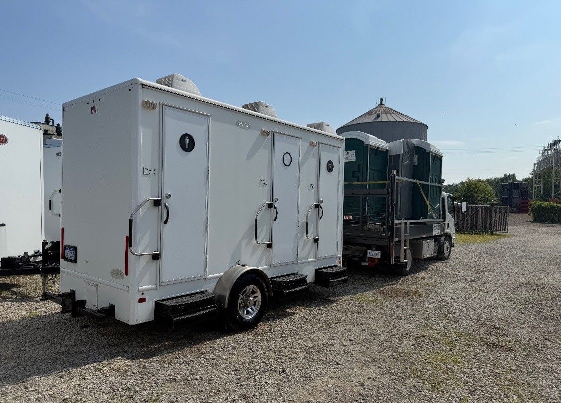 White utility trailer and dark green truck parked on a gravel lot under a clear sky White utility trailer and dark green truck parked on a gravel lot under a clear sky