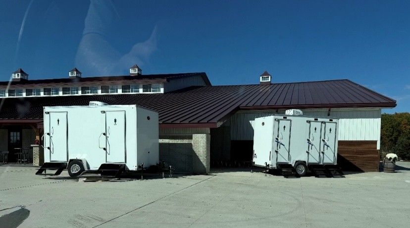 White trailers parked beside a small building with a brown roof under a clear blue sky White trailers parked beside a small building with a brown roof under a clear blue sky