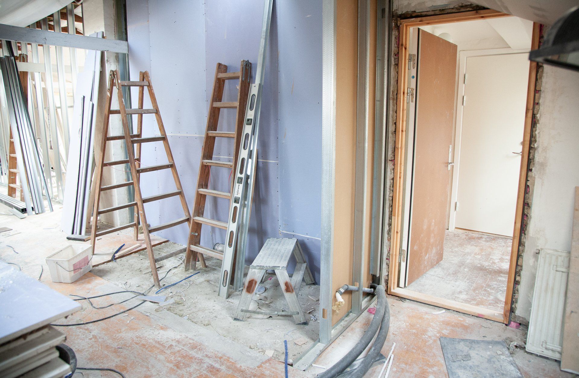 Construction A room under construction with a ladder and a stool
