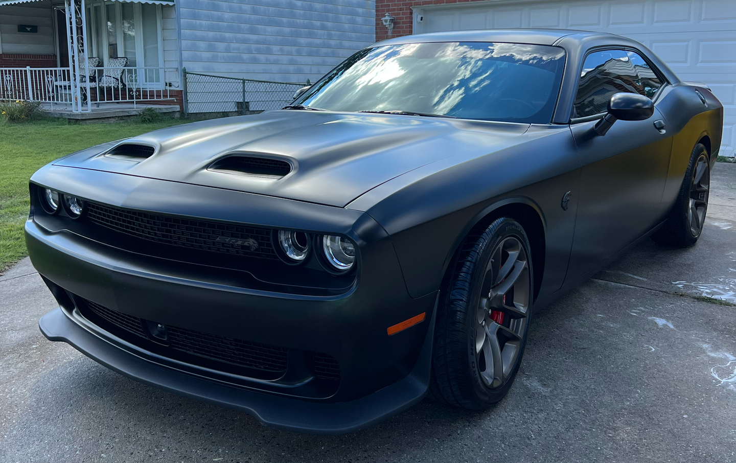Black Dodge Challenger parked in a driveway.