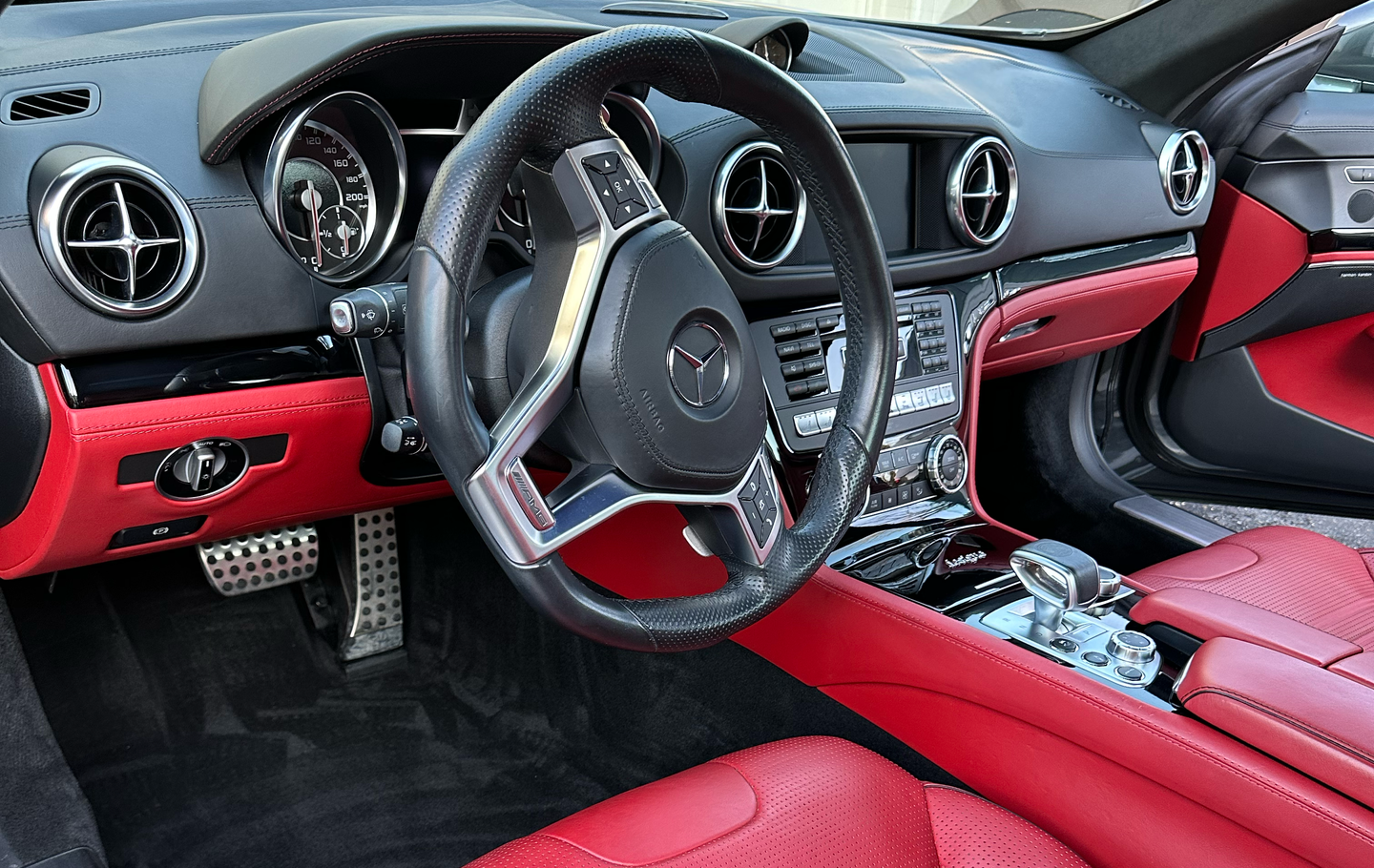 Red and black Mercedes-Benz SL interior with leather seats, dashboard, and steering wheel.